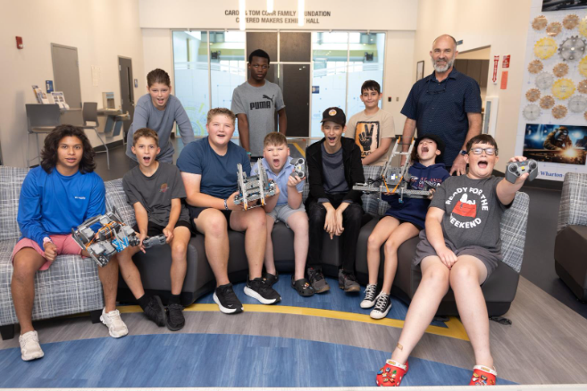 A photo showing young engineers getting hands-on experience building and programming robots at an Indian River State College youth robotics program or camp.